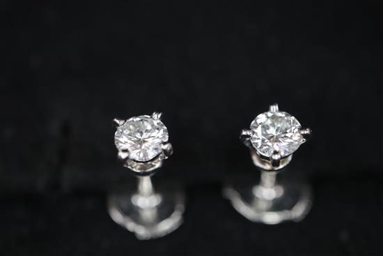 A pair of Cartier platinum set solitaire diamond ear studs, with Cartier box.